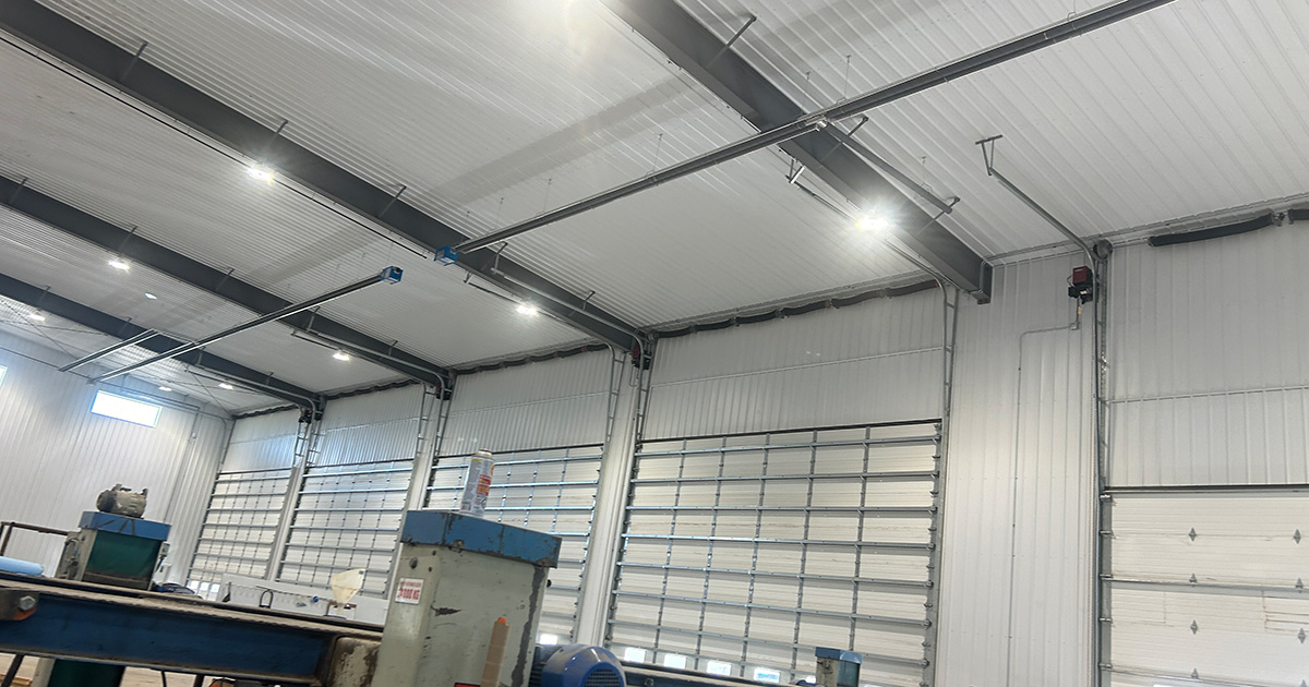 Clean workshop with Reflect-O-Ray low-intensity infrared heating showing dry walls, clear air, and warm structural surfaces.